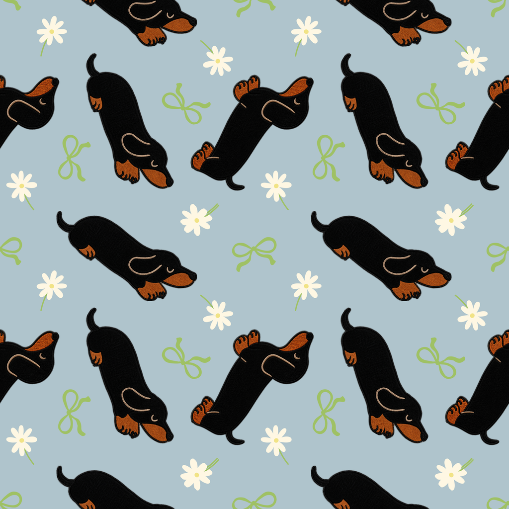 Pattern of small black dogs with brown accents on a light blue background with white flowers and green bows.